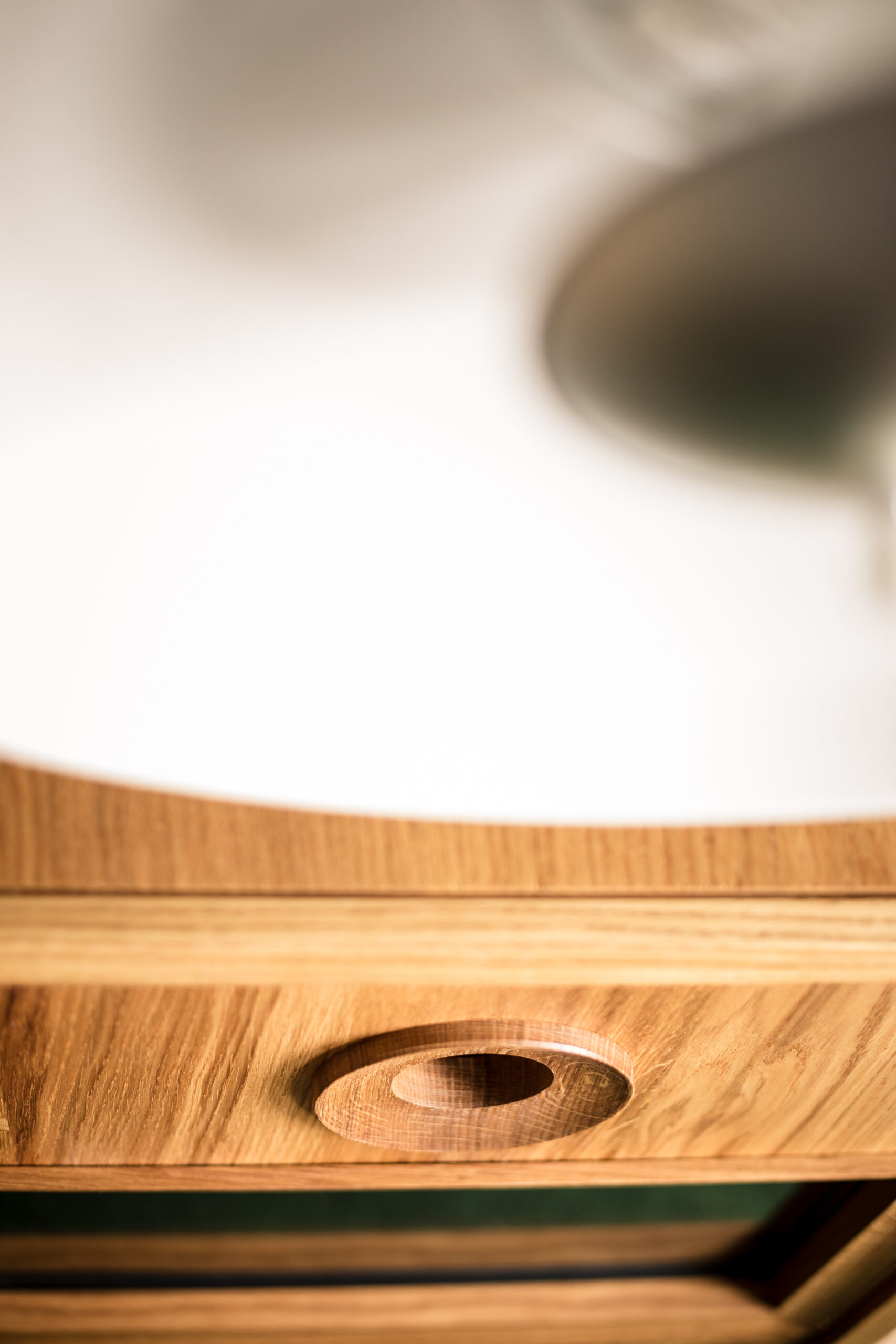 Close-up van houten bureau door fotograaf, met lichte houtnerf en een rond gat. Artistieke opname in Brugge, West-Vlaanderen. Perfect voor trouw- of familiefotografie.