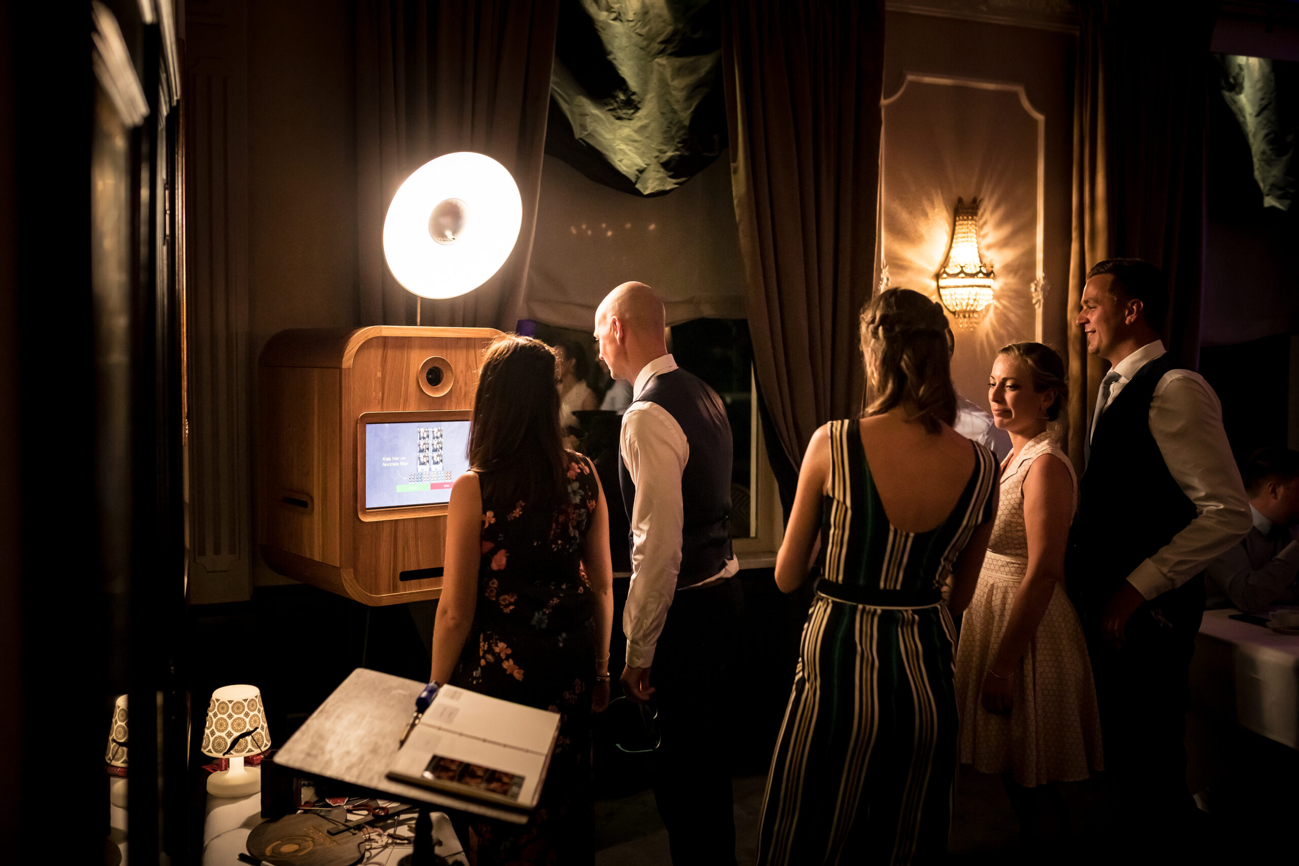 Fotograaf in actie bij vintage fotocabine in Brugge, West-Vlaanderen tijdens formeel evenement.